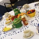 彩色桌面显示, 绿色茶壶, 杯子和碟子, 柠檬片, 茶的种类和手指食物
